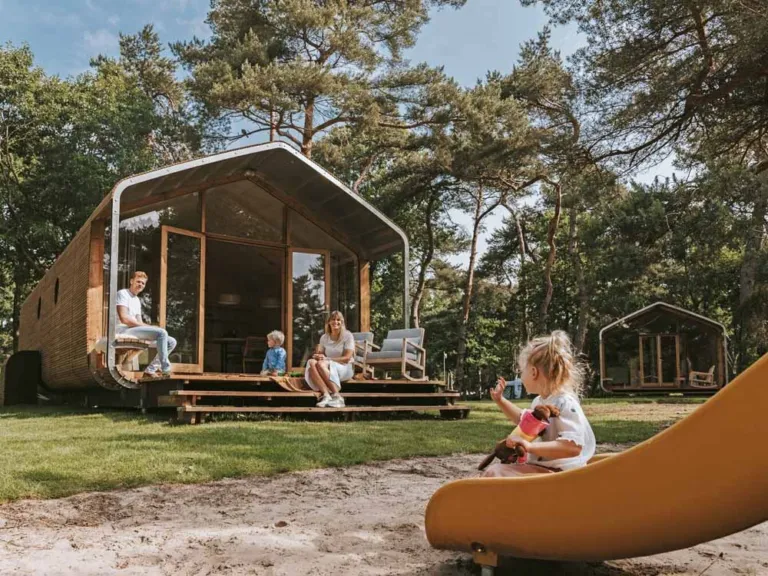 Gezin op het terras van een vakantiewoning tussen de bomen op Beerze Bulten