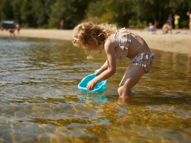 Kind speelt aan de recreatieplas naast Landal De Vlegge