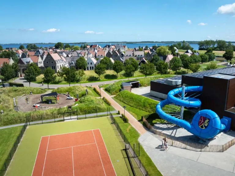 Het sportveld en de blauwe buitenglijbaan van het zwembad op Landal Esonstad