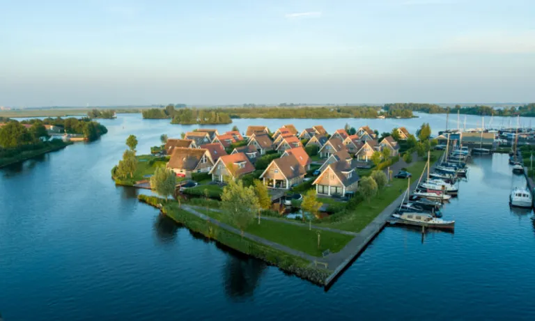 Luchtfoto van Landal Waterpark Terherne op een landtong, met de jachthaven vol zeilboten