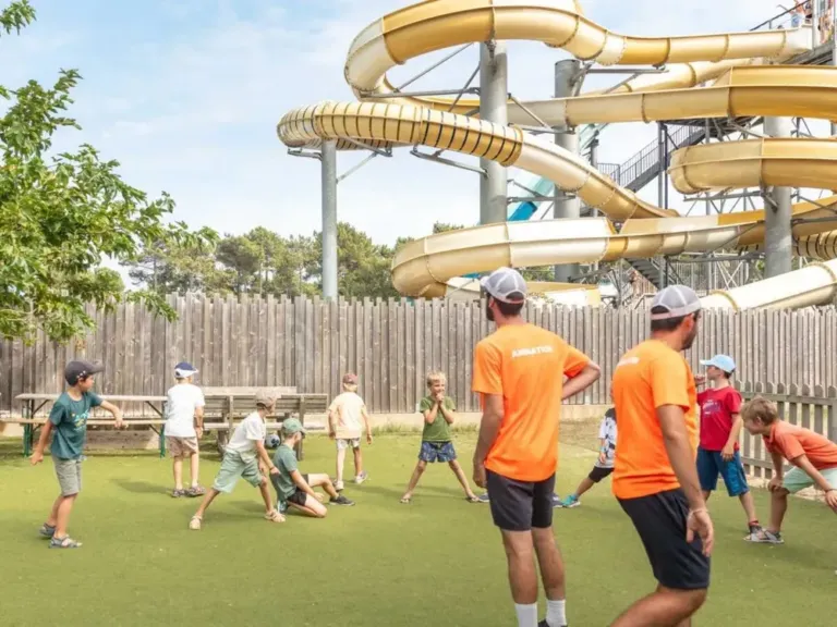 Animatie met glijbanen op de achtergrond op camping Atlantic Club Montalivet
