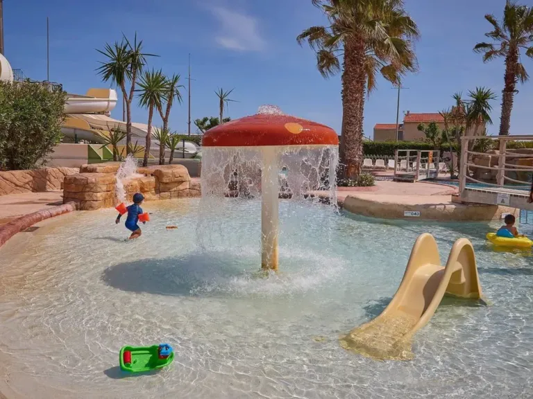 Kinderbad met glijbaantje en paddenstoelensproeier op camping Le Petit Mousse