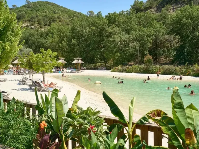 Lagunebad met zandstrand en ligbedden op camping Verdon Parc