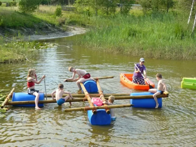 Kinderen bouwen een vlot in de zwemvijver van Minicamping Falkenborg